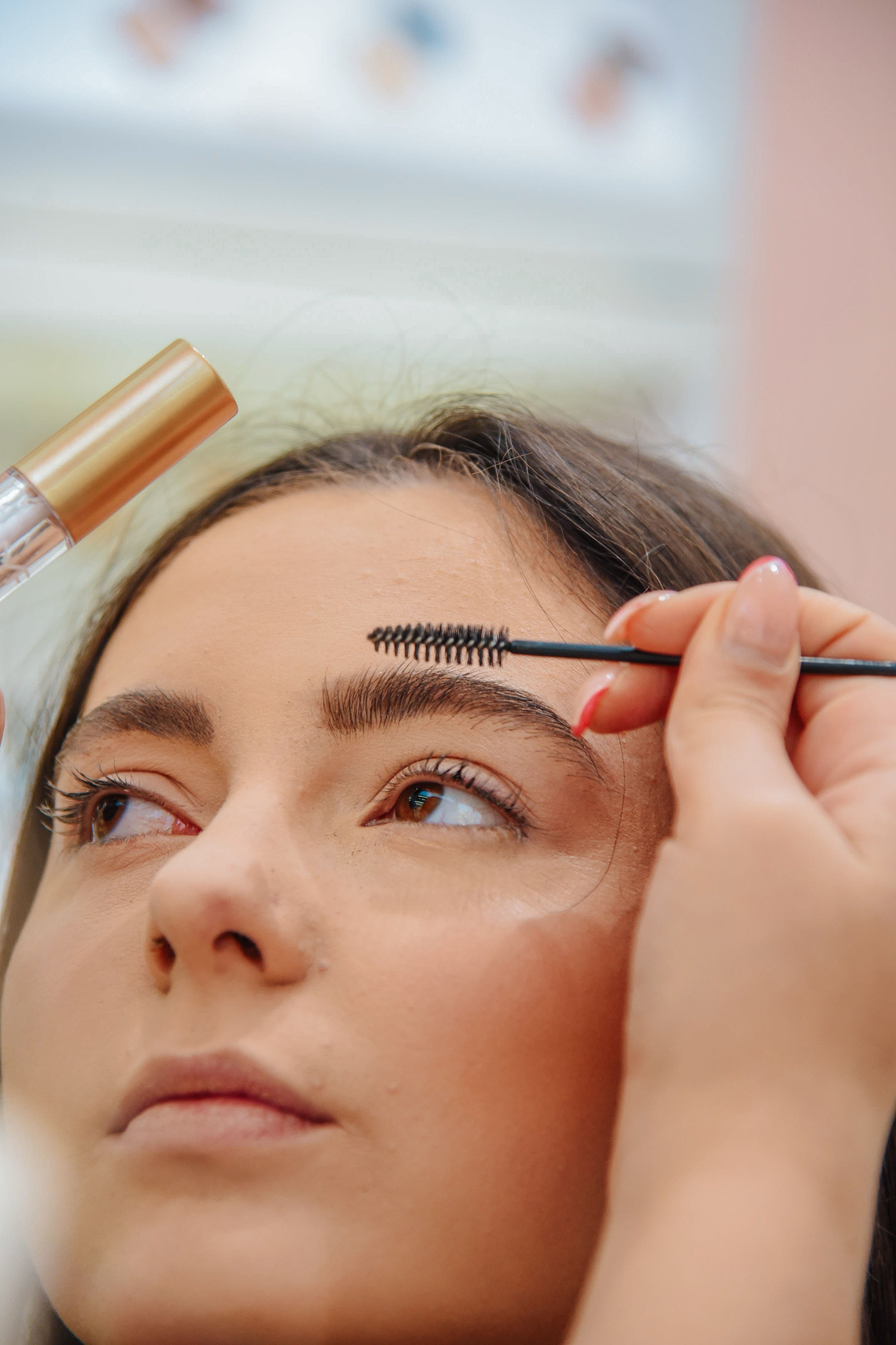 Close-up of a stylist brushing a client's brows during a lamination treatment