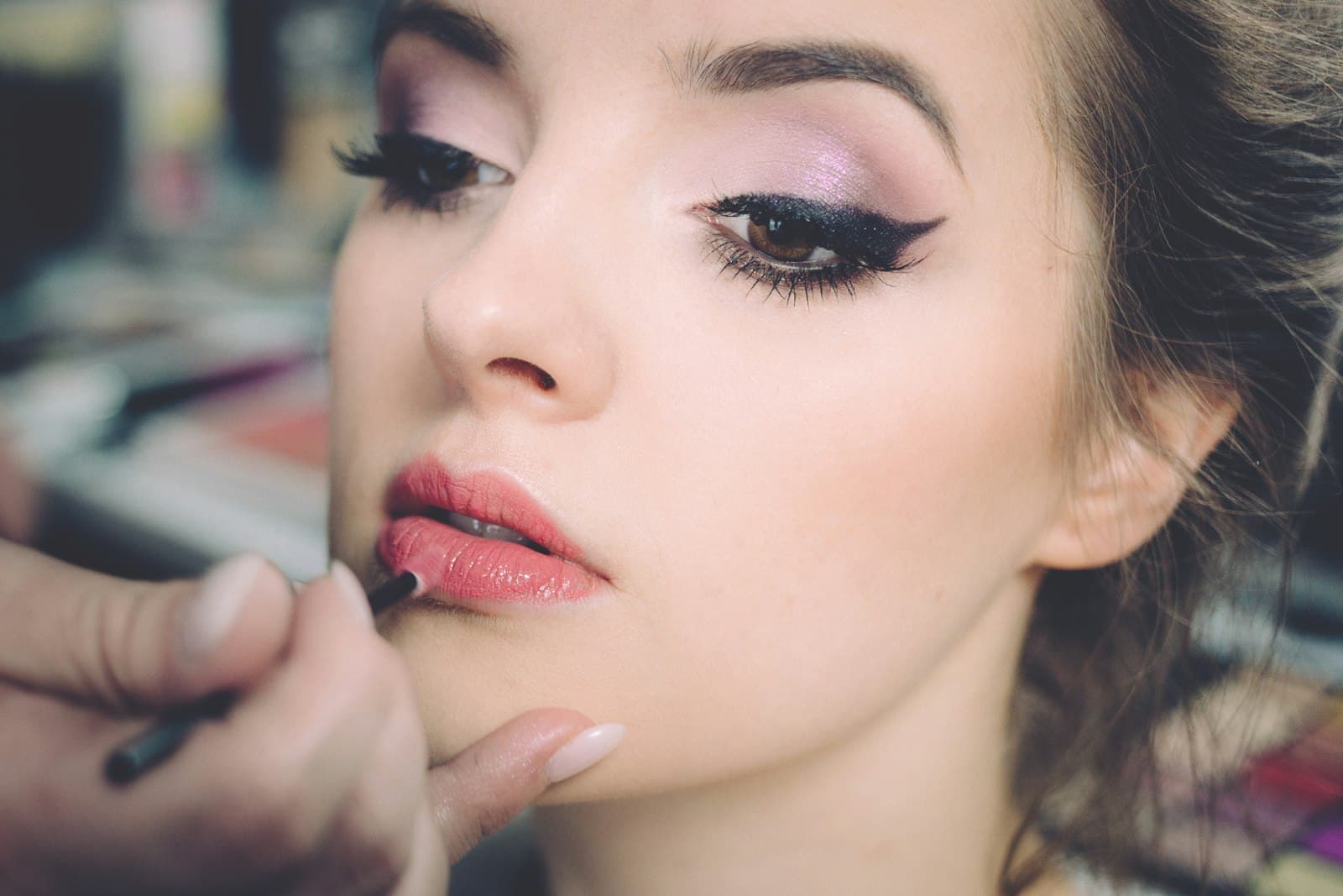 Close-up portrait of a client mid-appointment, showing polished brow and lip work